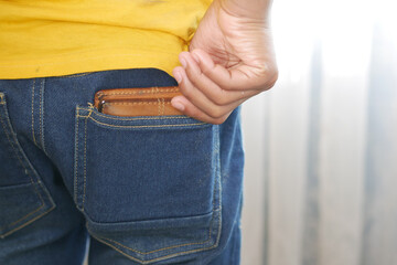 young man taking wallet out from back pocket 