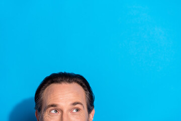 Portrait of attractive cheerful curious brown-haired man looking copy space isolated over bright blue color background