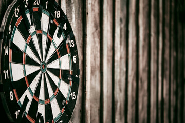 Darts board on an old wooden wall. Background concept - unfulfilled goals, ruined business,...