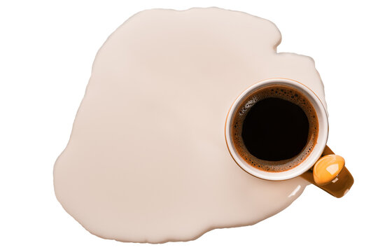 Small mug with black coffee in a puddle of milk, top view, isolated.