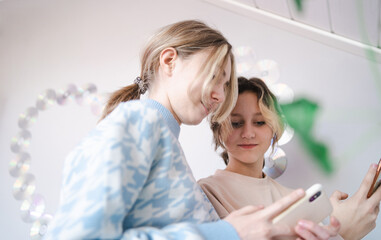 Zwei Mädchen im Teenager-Alter schauen auf das Handy