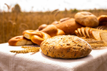 lot of different flavored bread, wheat, rye, on the table in the field outside