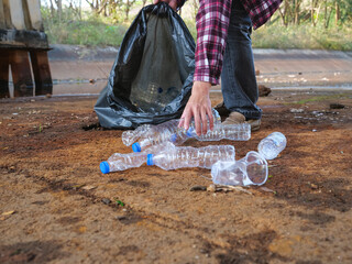 Volunteers pick up plastic bottles in the park.