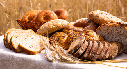 lot of different flavored bread, wheat, rye, on the table in the field outside