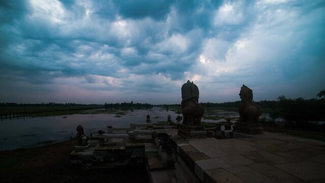Moody storm clouds over Banteay Chhmar Baray early morning.  Time lapse of Dark cloud movement over the Angkorian lion carvings similar to Sra Srang, Angkor Wat.