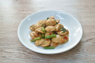 spicy stir fried slice pork meatball with yard long bean and basil leaf on plate