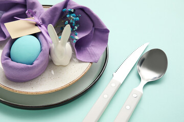 Stylish table setting for Easter celebration on turquoise background