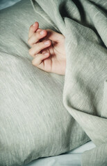 child's hand under the blanket close-up