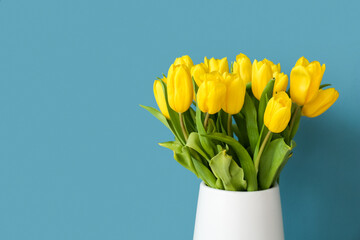 Vase with tulips on blue background