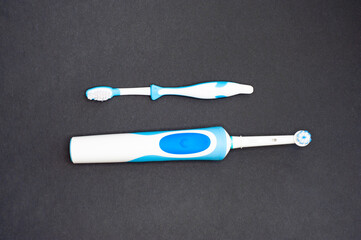 Modern electric toothbrush standing on a black background. Controlled tool for daily oral care