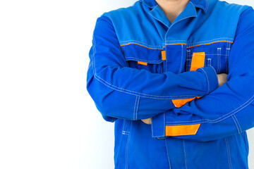 A man in blue work clothes on a white background with his arms crossed.	
