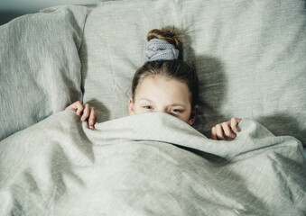 sleepy teen girl under the covers