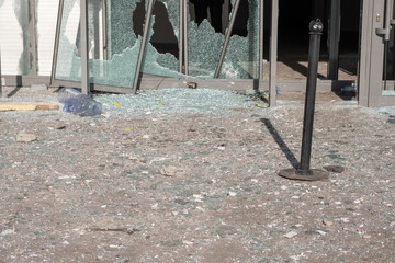 Destroyed automatic sliding glass doors in entrance of building due to vandalism. Looted shopping mall concept.