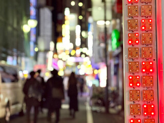 夜の歌舞伎町を歩く人々のボカシイメージとネオン