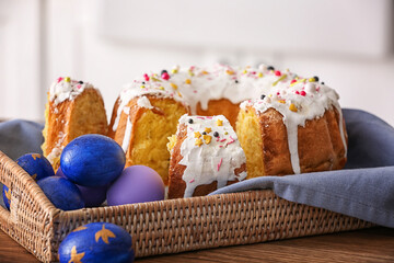 Tray with pieces of tasty Easter cake and eggs on table, closeup