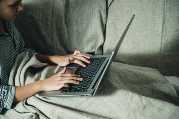 hands and laptop on the bed close-up