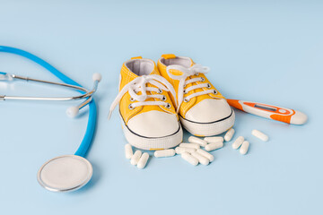The concept of children's health and treatment. Children's shoes with stethoscope. Place for text