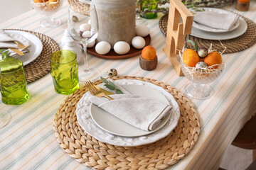 Beautiful Easter table setting with eggs and stylish dinnerware