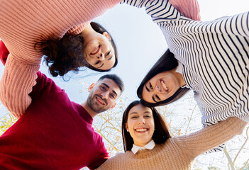 Portrait of four happy friends laughing and posing looking at you