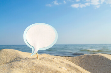 Paper Empty Blue White Blank Speech Bubble on Stick in Sandy Sea Beach on Background Clean Blue Sky and Sea Close-up Sunny Summer Day. Concept Travel Tourism Vacation Rest. Copy Space, Space for Text