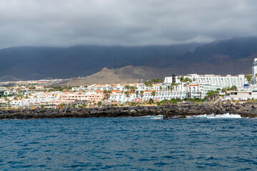 Obraz premium View on resorts and beaches of South coast of Tenerife island during sail boat trip along coastline, Canary islands, Spain