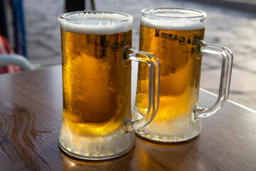Two pint glasses with cold beer served outdoor