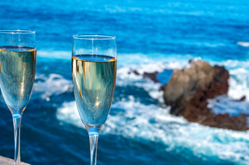 New year celebration with two glasses of champagne or Spanish cava sparkling wine and view on blue Atlantic ocean, Canary islands, winter tourists destination