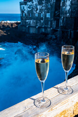 New year celebration with two glasses of champagne or Spanish cava sparkling wine and view on black lava rocks, Canary islands, winter tourists destination