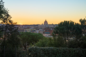 View of Rome skyline and the Vatican at sunset, with Saint Peter basilica's cupola as a silhouette from Pincio viewpoint, Italy