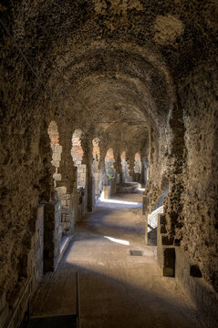 Underground gallery in Catania Roman theater, Italy. Peripheral underground gallery or vomitorium made out of volcanic stones, curving around the Ancient Roman amphitheater of Catania in Sicily, Italy