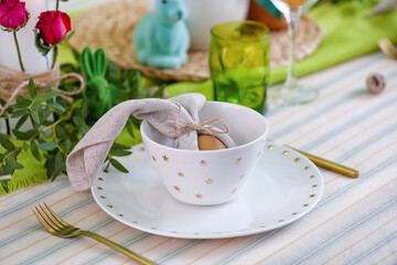 Bowl with Easter egg in napkin on served table, closeup