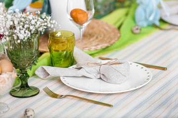Plate with Easter egg in napkin on served table