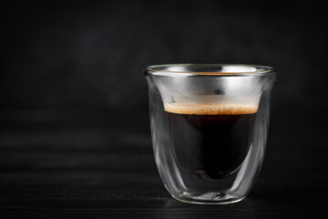 Hot freshly brewed espresso coffee in a double walled shot glass
