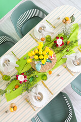 Festive setting with beautiful flowers and candles on table served for Easter celebration