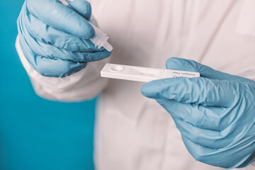 Doctor in medical PPE suit using a covid-19 rapid antigen test, web banner