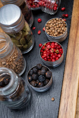 Professional set of gin spices in small bottles, pink pepper, hibiscus flowers, juniper berries, cardamom and coriander seeds