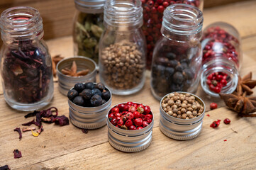 Professional set of gin spices in small bottles, pink pepper, hibiscus flowers, juniper berries,...