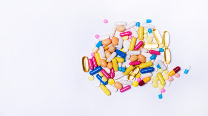 Various colorful pills and capsules on a white background. The concept of medicine and treatment. Copy space