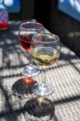 Two glasses of cold rose and white wines in lounge bar on sunny day