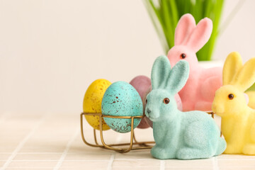 Cute Easter bunnies and holder with eggs on table, closeup