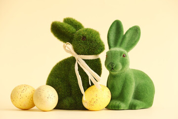 Green Easter bunnies and eggs on color background