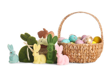 Basket with Easter eggs, bunnies and cake on white background