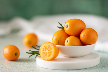 ripe juicy kumquat fruits in a white bowl