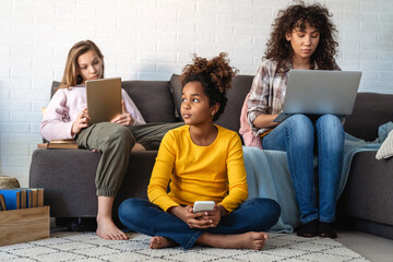 Group of multiethnic teenagers with modern gadgets and laptop having fun, studying together at home