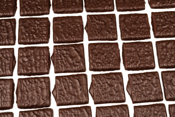 Dark chocolate candies isolated on white background.