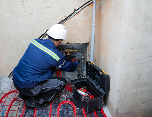 Technician installing underfloor heating collector
