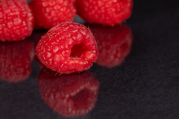Raspberries on a black mirror background