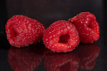 Raspberries on a black mirror background