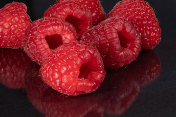 Raspberries on a black mirror background