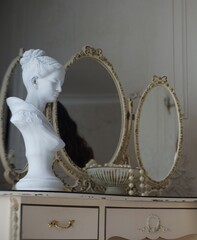 a antique statue on a table with mirrors